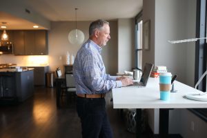 Mann arbeitet am Stehtisch